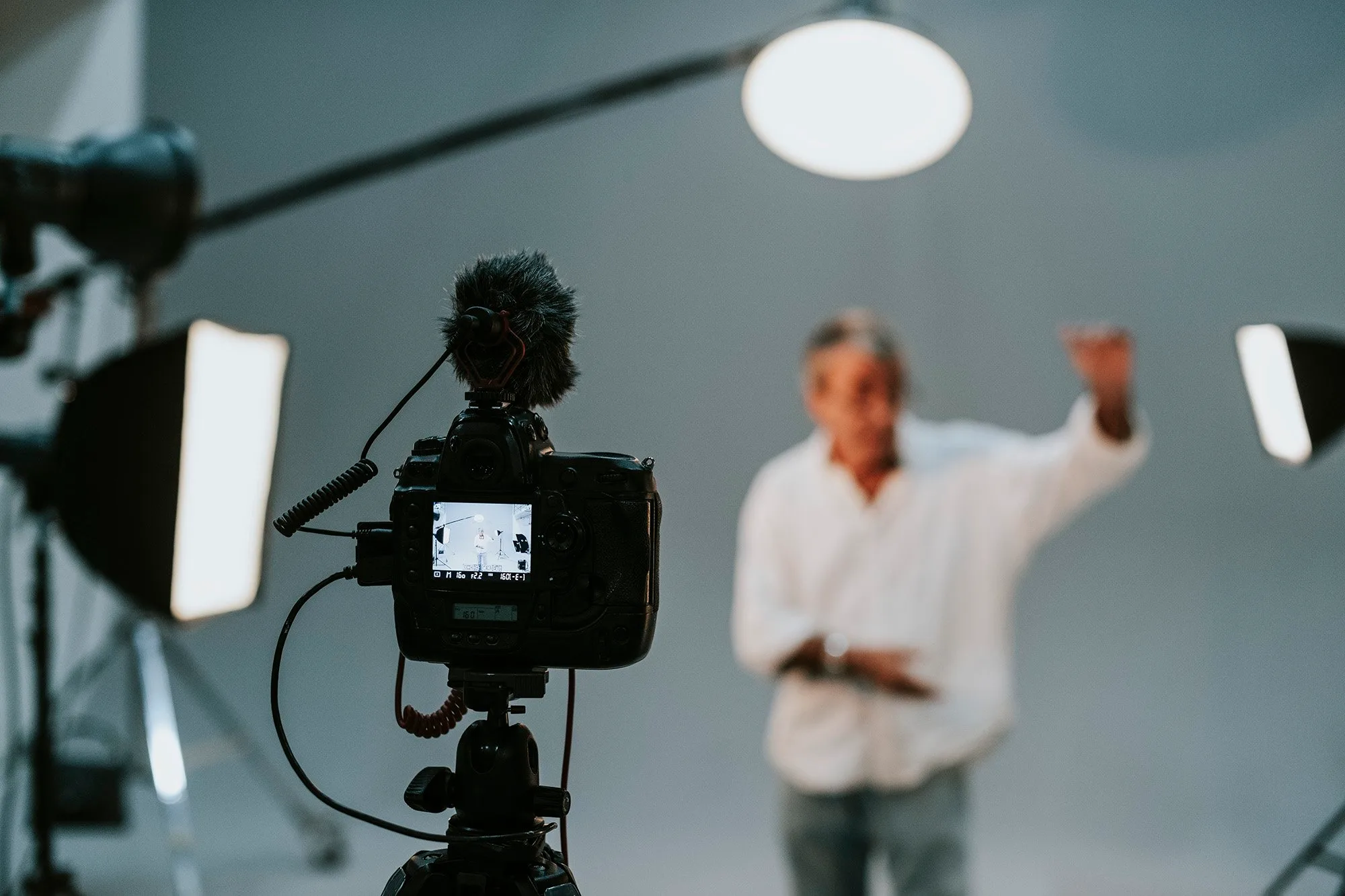 Cinema camera and studio lighting framing an on-camera speaker at a corporate video shoot