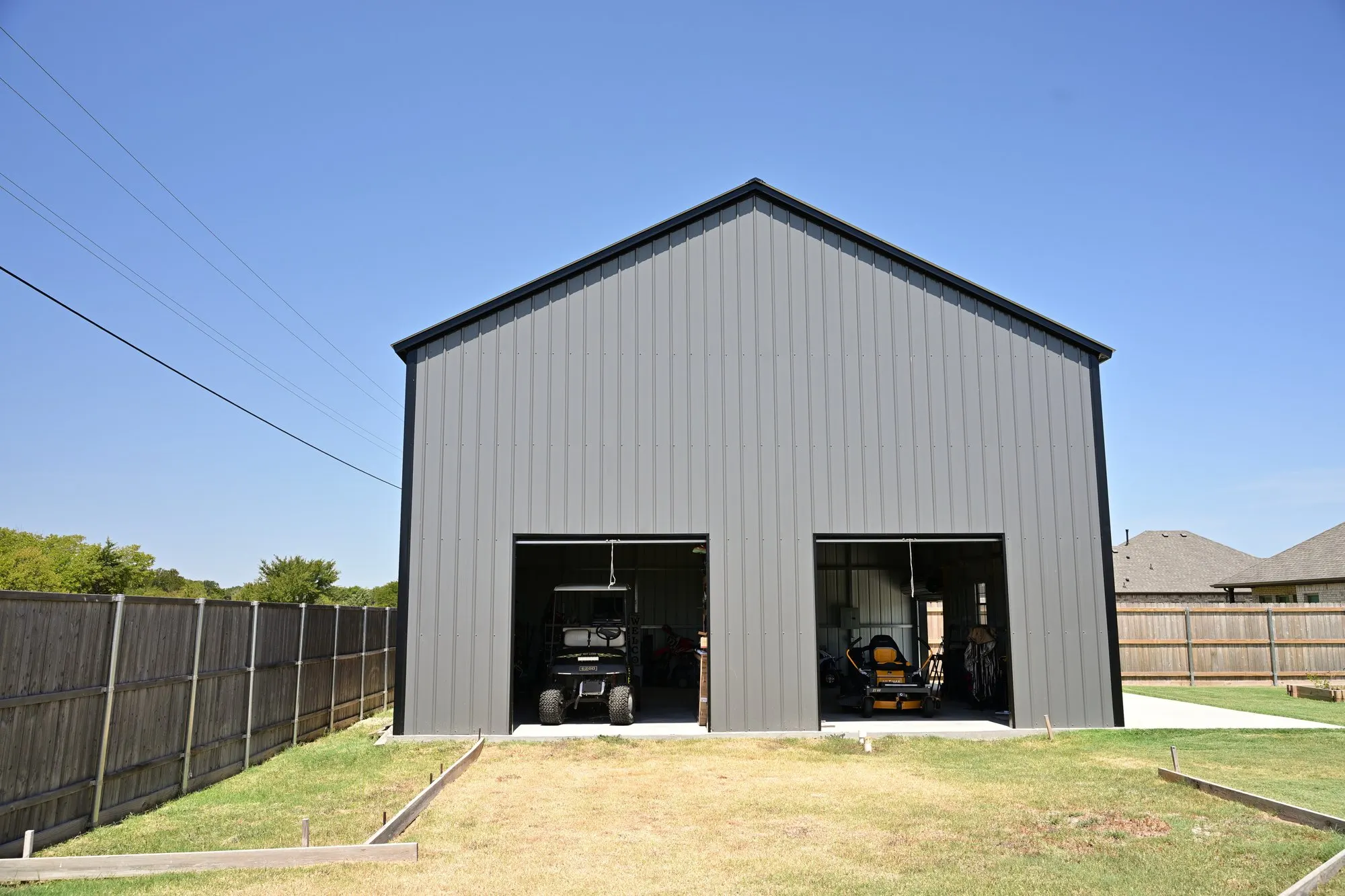 Front elevation of the custom metal shop with both roll-up doors open