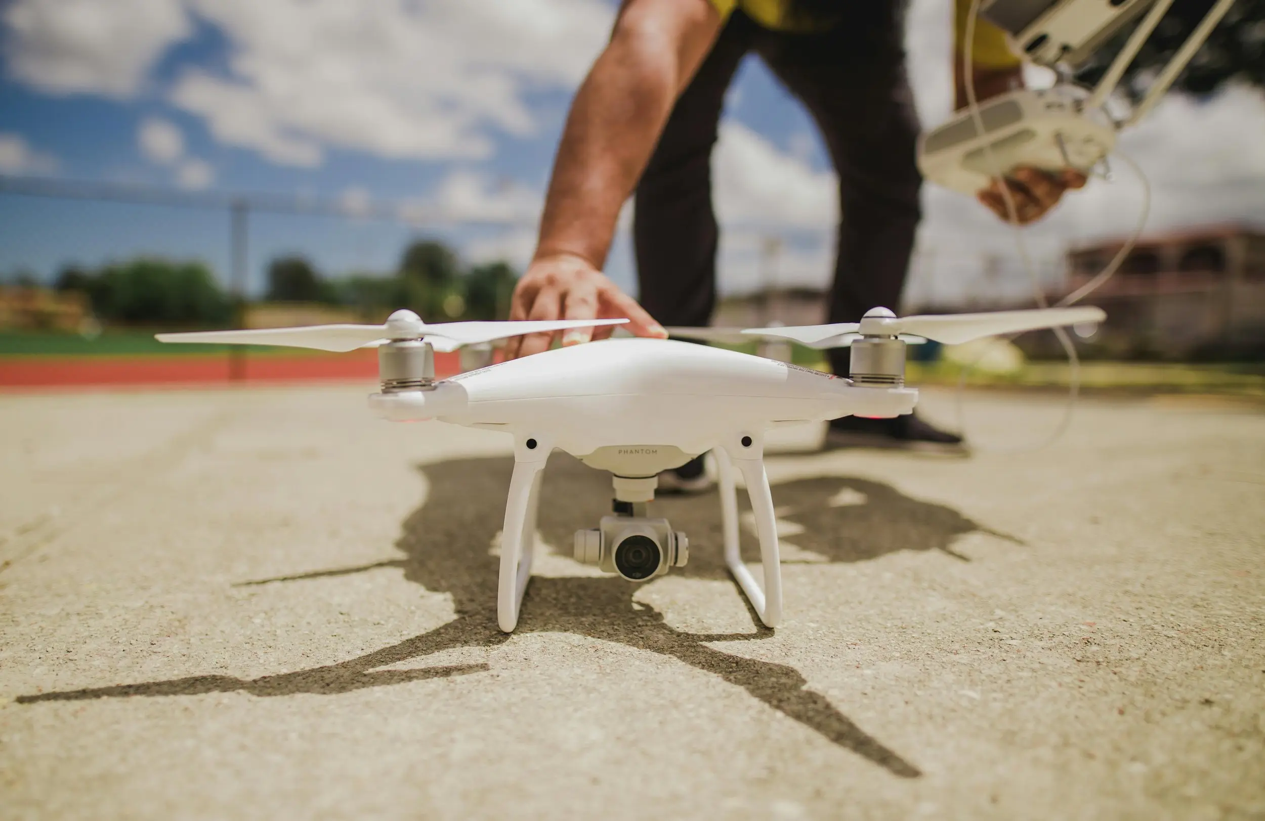 Commercial drone pilot setting a quadcopter on the ground before an inspection flight