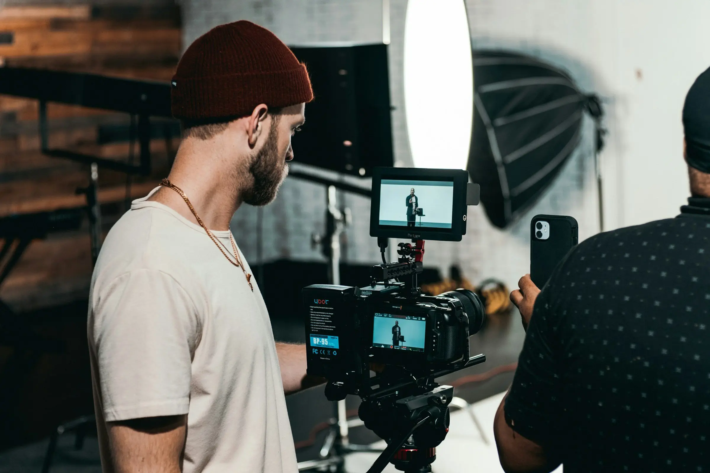 Videographer checking the interview frame on camera and field monitors