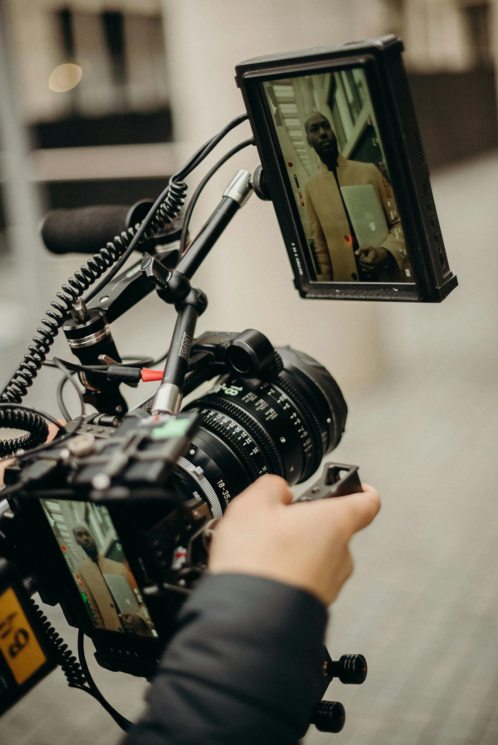 Camera operator filming an interview subject with a cinema rig and field monitor