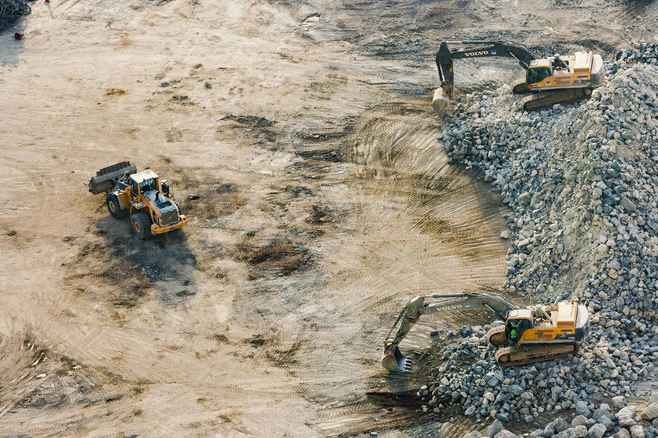 Overhead drone photo of excavators and a wheel loader working a construction site