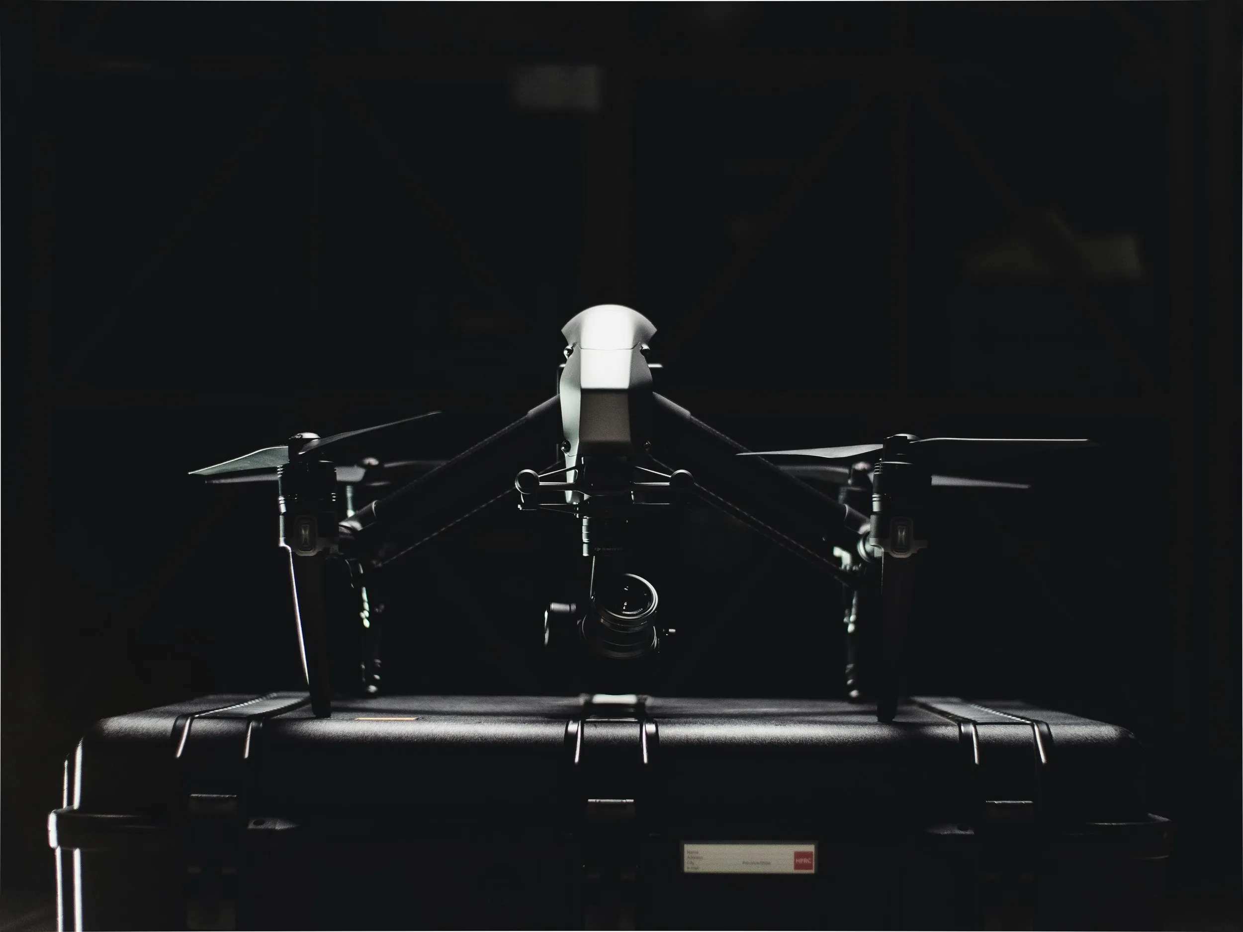 Professional cinema drone resting on an equipment case in low light