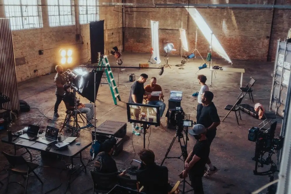 Production crew reviewing notes on a corporate video set in a warehouse studio