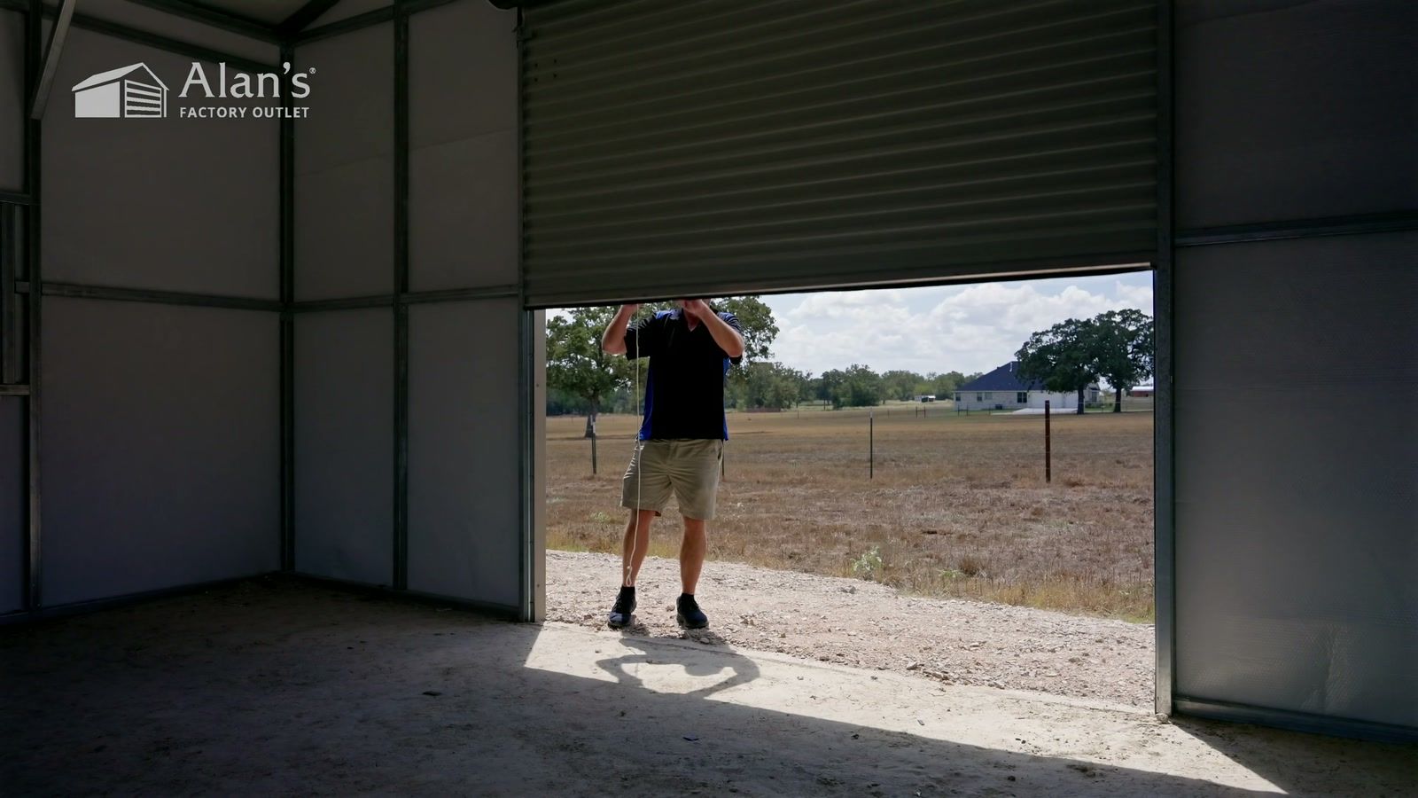 Kyle opening the roll-up door of his new metal building