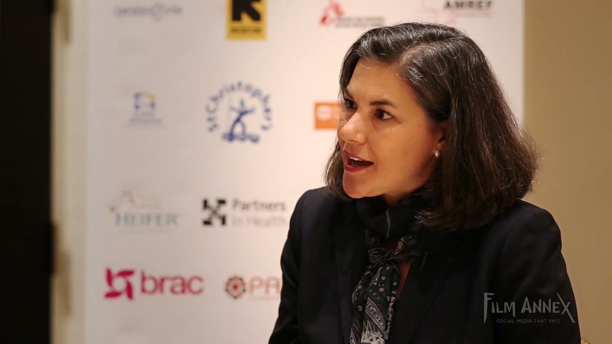 Beth MacNairn of Handicap International US interviewed in front of an event press wall